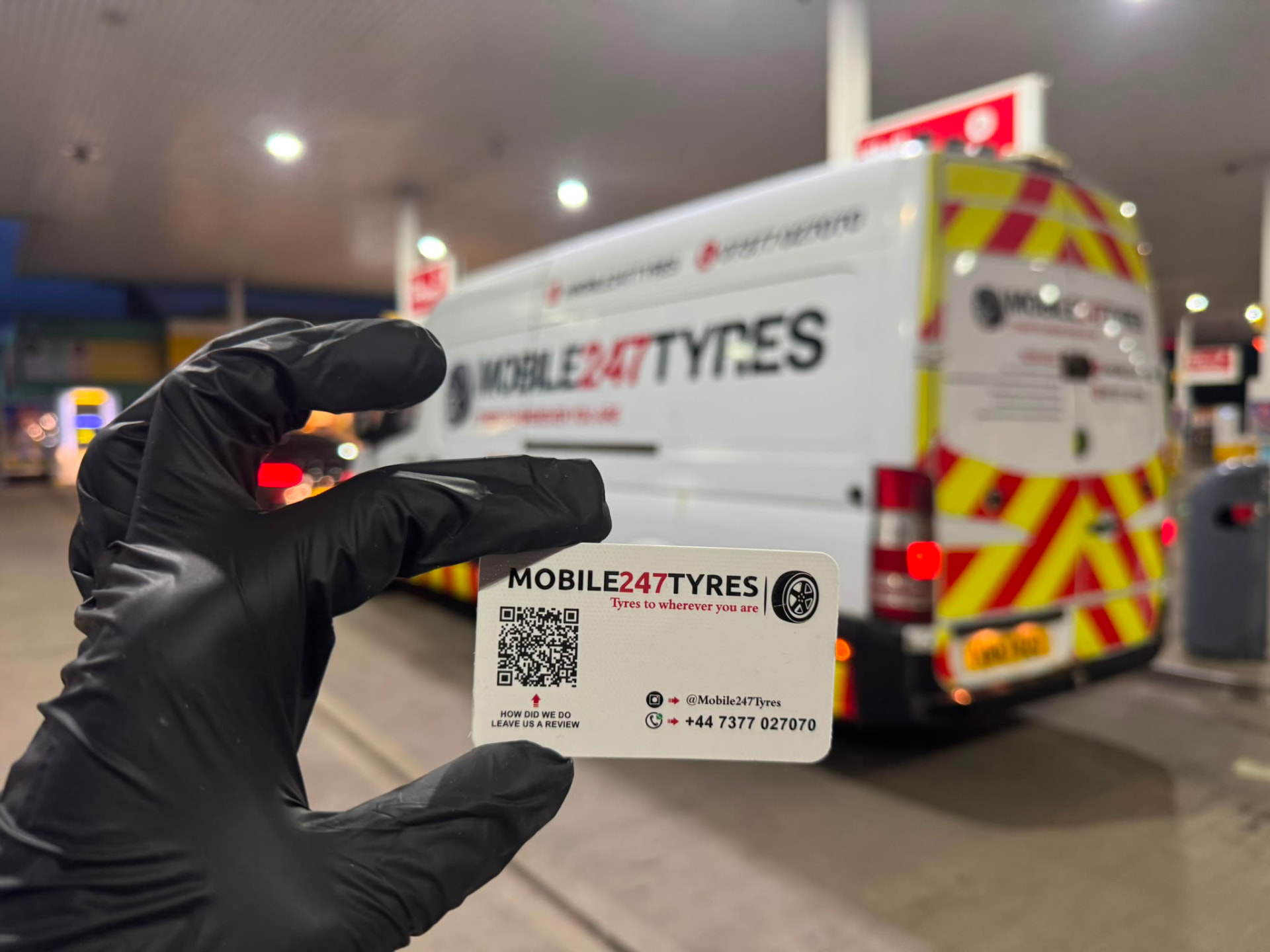 Mobile 247 Tyres business card held by a fitter