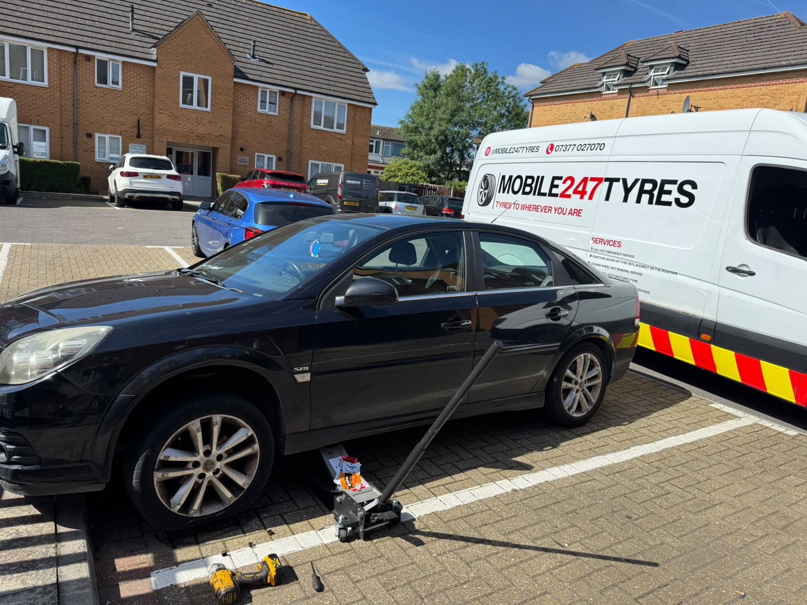 Vauxhall Vectra jacked up for a tyre replacement in a car park